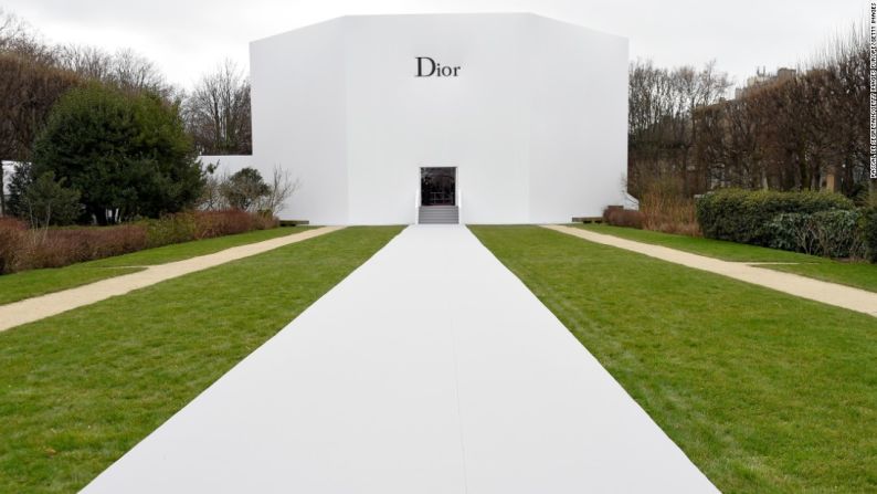 Dior Alta Costura primavera/verano 2015 – En contraste con su ocupado interior, el exterior completamente blanco del escenario primavera/verano 2015 de Dior resaltaba frente al verdor del telón de fondo de un jardín parisino.