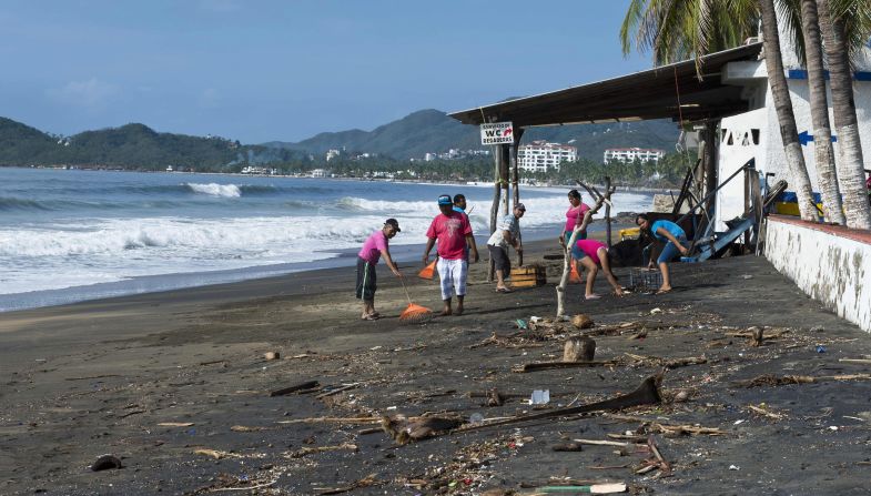 Residentes de los suburbios de Manzanillo, Colima, limpian la playa de un restaurante, tras el paso del huracán Patricia por los estados del Pacífico mexicano.