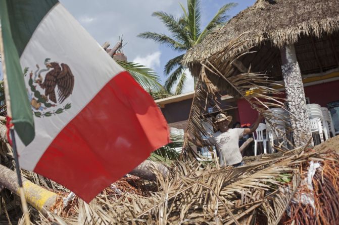 Un trabajador limpia los escombros dejados por el paso del huracán en un restaurante de la playa en Melaque, Jalisco.