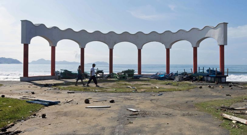 Una pareja camina cerca de la playa en un suburbio de Manzanillo, Colima, solo unas horas después del paso del huracán Patricia.