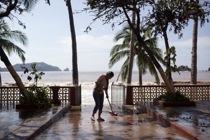 Una mujer limpia la salida a la playa de un hotel en Melaque, Jalisco, un día después del impacto del huracán Patricia.