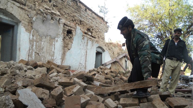 Un hombre un Pakistán recoge los escombros tras el terremoto.