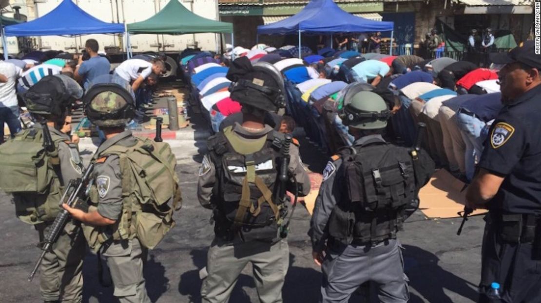 Fuerzas de seguridad Israelíes rodean fieles musulmanes durante la oración del viernes.