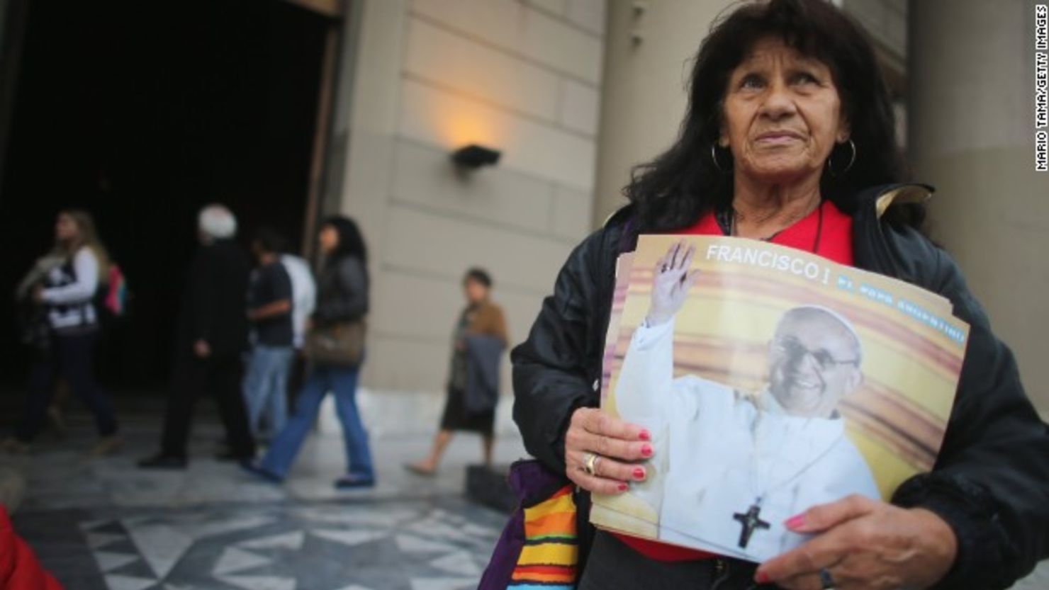 María del Tránsito Díaz sostiene fotos del papa Francisco en Buenos Aires, un día después de su elección como pontífice.