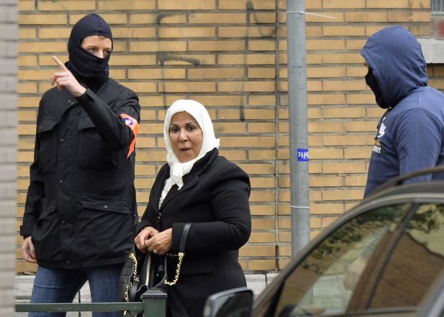 La policía escolta a una mujer para que salga de la escena de la operación que se realizó en la mañana del lunes en el distrito de Molenbeek, en Bruselas.