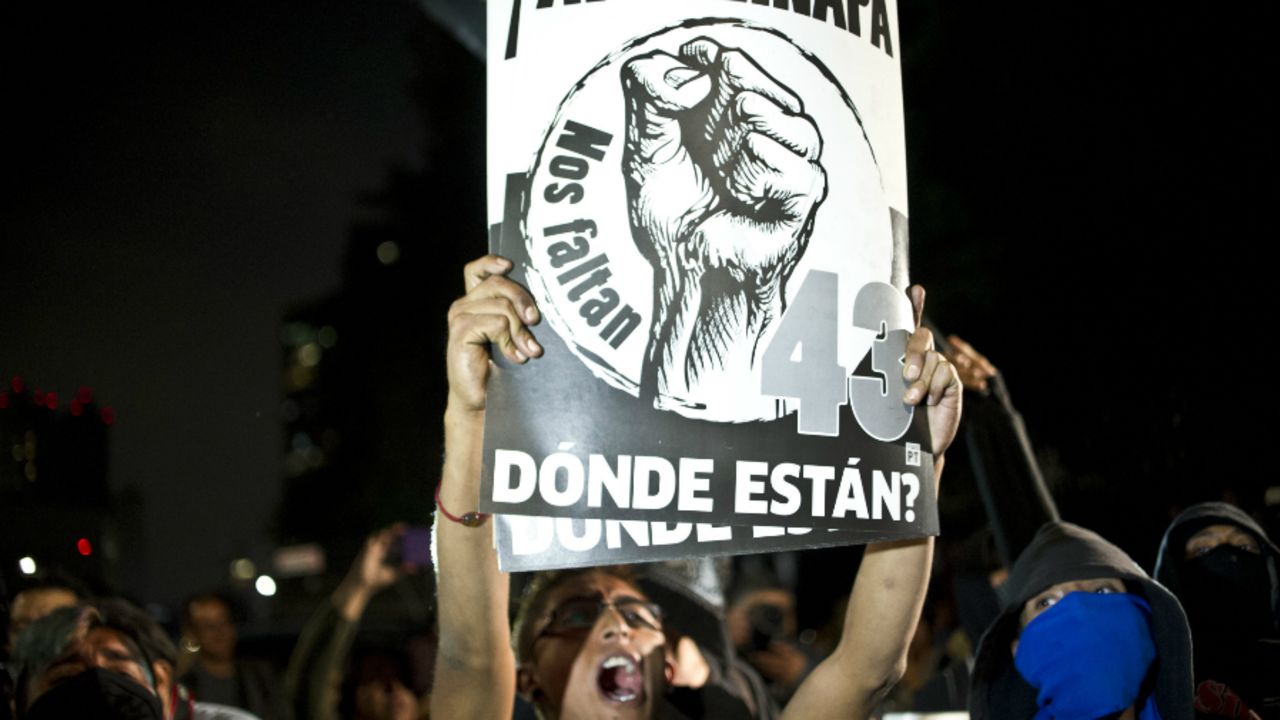 Una mujer sostiene un cartel durante el 'plantón' de los familiares de los 43 estudiantes desaparecidos.