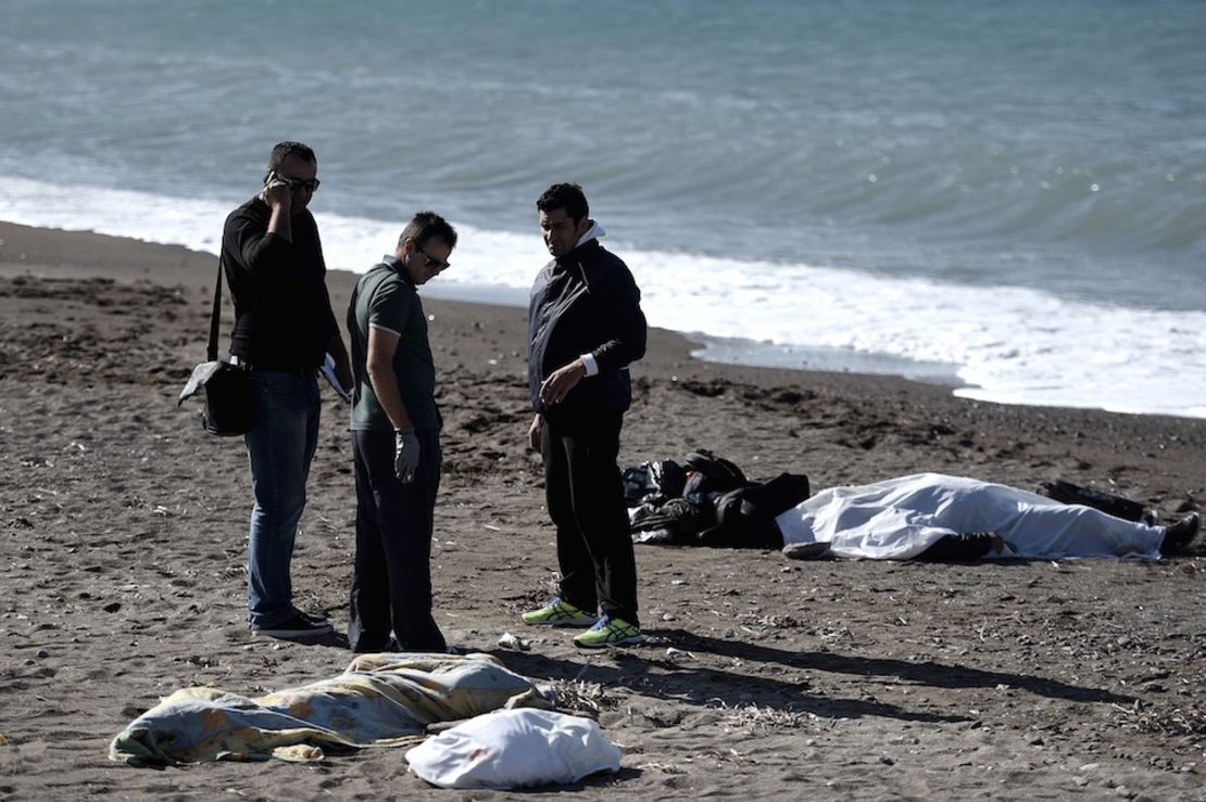 Oficiales de policía cerca a los cuerpos sin vida de dos niños y un hombre que se ahogaron al intentar cruzar el mar Egeo desde Turquía,hacia la isla griega de Lesbos, el 30 de octubre de 2015.