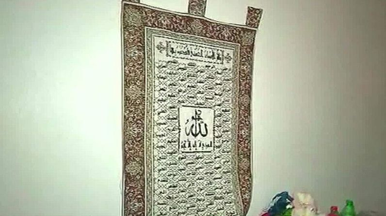 También hay una alfombra colgada con escrituras en árabe y una copia del Corán