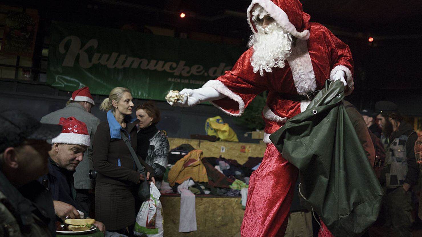 Un  hombre vestido de Santa Claus entrega regalos a desamparados en Berlín en 2013