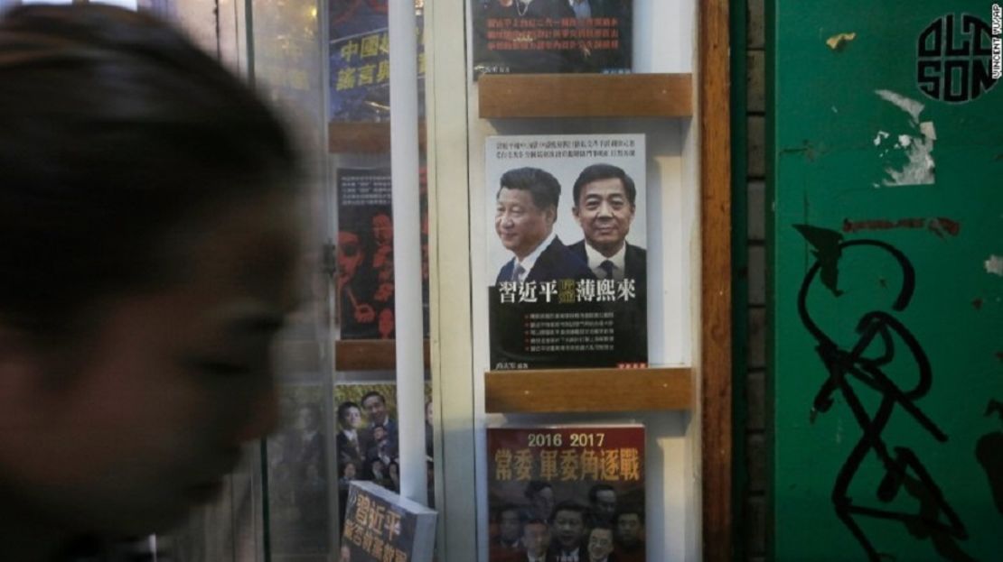 Una mujer pasa junto a un libro en el que aparece en la portada el presidente de China, Xi Jinping, a la izquierda, el exmiembro del Buró Político y el líder del partido de la ciudad de Chongqing, Bo Xilai, en la entrada de la librería cerrada Causeway Bay, el domingo, 3 de enero de 2016.