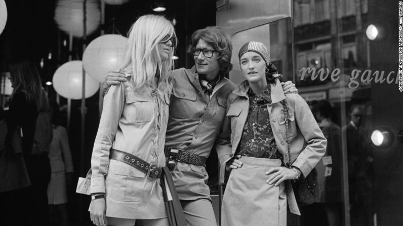 Yves Saint Laurent – Yves Saint Laurent estaba al timón creativo de Christian Dior antes de expandir sus horizontes para comenzar su propio sello del mismo nombre en 1960. Yves Saint con sus amigas y musas, Betty Catroux y Loulou de la Falaise, afuera de su tienda en Paris, Rive Gauche, 1969.