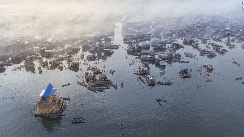 Iwan Baan/NLÉ Architects - Una fotografía aérea de la Escuela Flotante Makoko por Kunlé Adeyemi de NLÉ Architects. Makoko es una comunidad informal grande en el centro de Lagos, donde cerca de 150.000 personas viven en estructuras construidas por sí mismos en el agua. La escuela de tres pisos es una estructura flotante en el borde de la comunidad, tomada por Iwan Baan en el 2013.