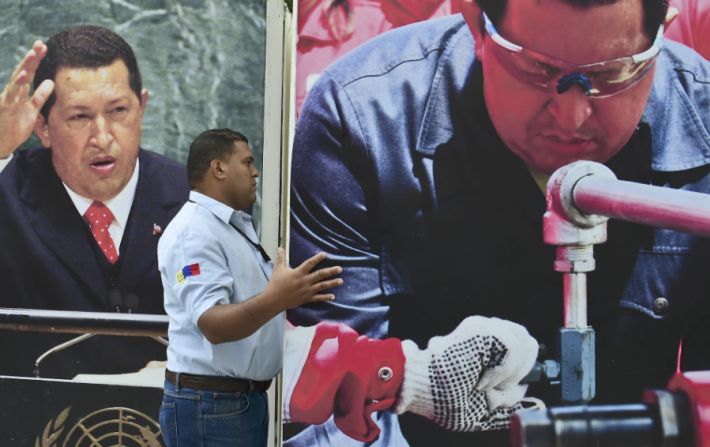 Un trabajador de la Asamblea Nacional de Venezuela retira el edificio una imagen del fallecido presidente Hugo Chávez.