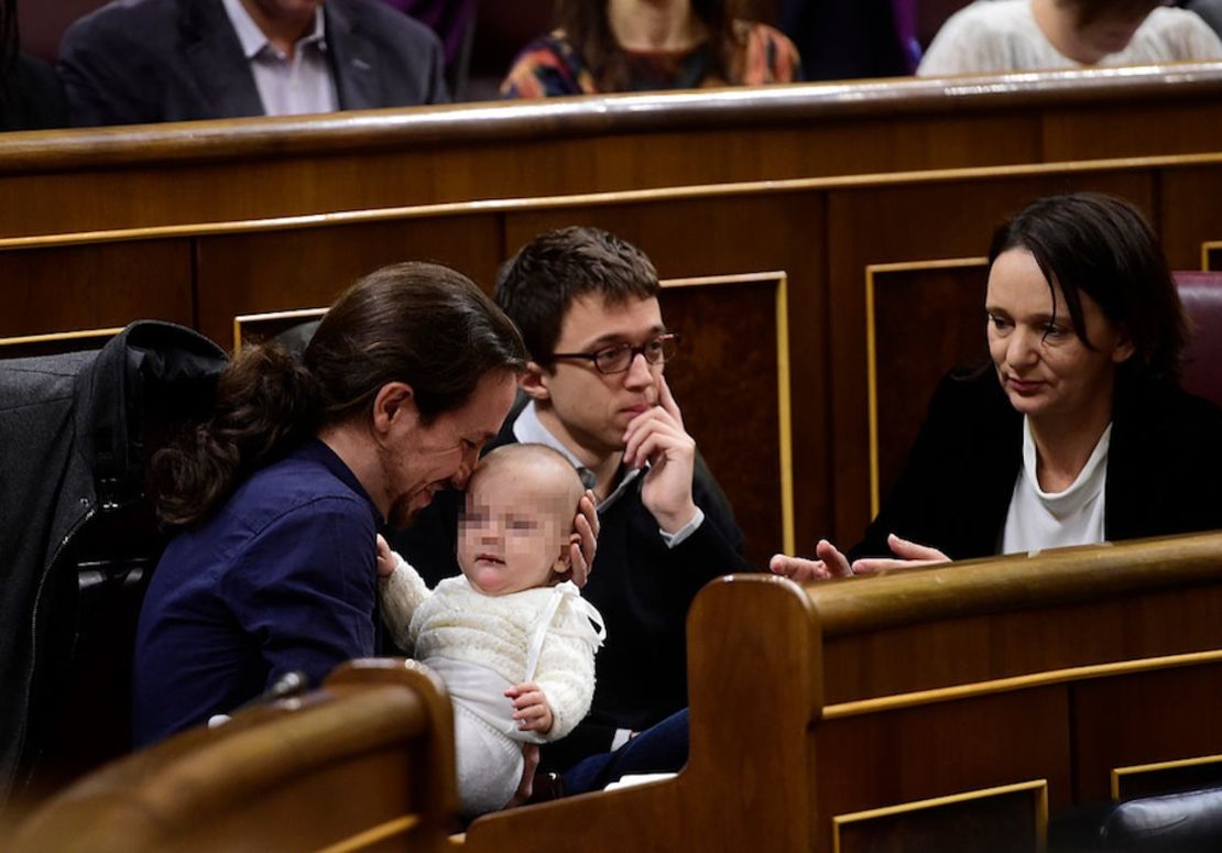 Left wing party Podemos' leader Pablo Iglesias (L) plays with the baby of Podemos' deputy Carolina Bescansa (R), past Podemos' member Inigo Errejon during the constitution of the Congress, at the Palacio de las Cortes in Madrid on January 13, 2016. Spain's parliament holds its first session today, with lawmakers from four conflicting main parties taking their seats at a time of political turmoil intensified by a resurgent secessionist threat in the Catalonia region. AFP PHOTO/ PIERRE-PHILIPPE MARCOU / AFP / PIERRE-PHILIPPE MARCOU