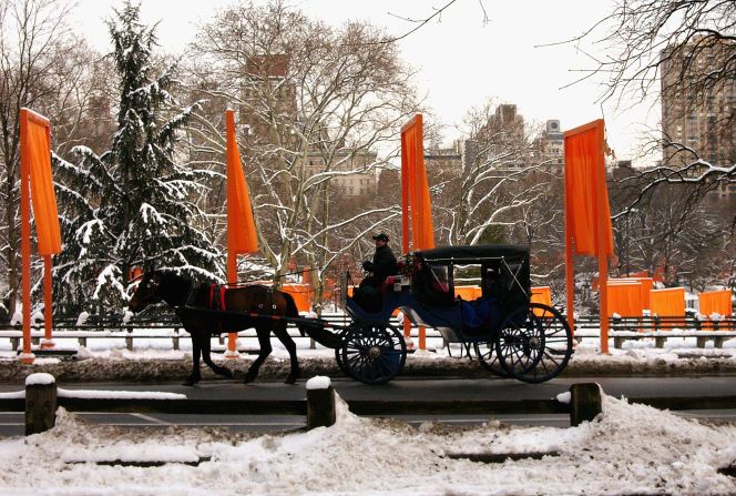 Una calesa pasa por la instalación artística "The Gates" (Las puertas) de los artistas Christo y Jeane Claude en Central Park, el 1 de marzo de 2005. Las "puertas" de tela cubrieron un poco más de 37 kilómetros de caminos pavimentados a través de todo el parque.