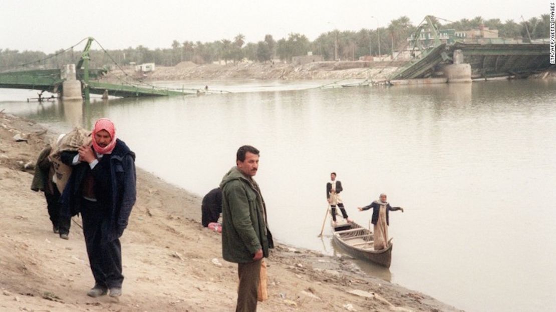 Habitantes de Samawah, a 280 kilómetros al sur de Bagdad, aparecen en imágenes utilizando pequeños botes para cruzar el río Éufrates el 17 de febrero de 1991, cuando tres puentes al centro de la ciudad fueron destruidos en las redadas aéreas por parte de los aliados en Iraq.