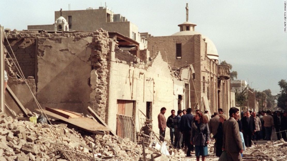 Una foto tomada el 16 de febrero de 1991 muestra a trabajadores civiles de defensa iraquíes y a civiles que veían el daño cerca de una iglesia cristiana, ocasionado por una redada de bombardeos por parte de los aliados en Bagdad.