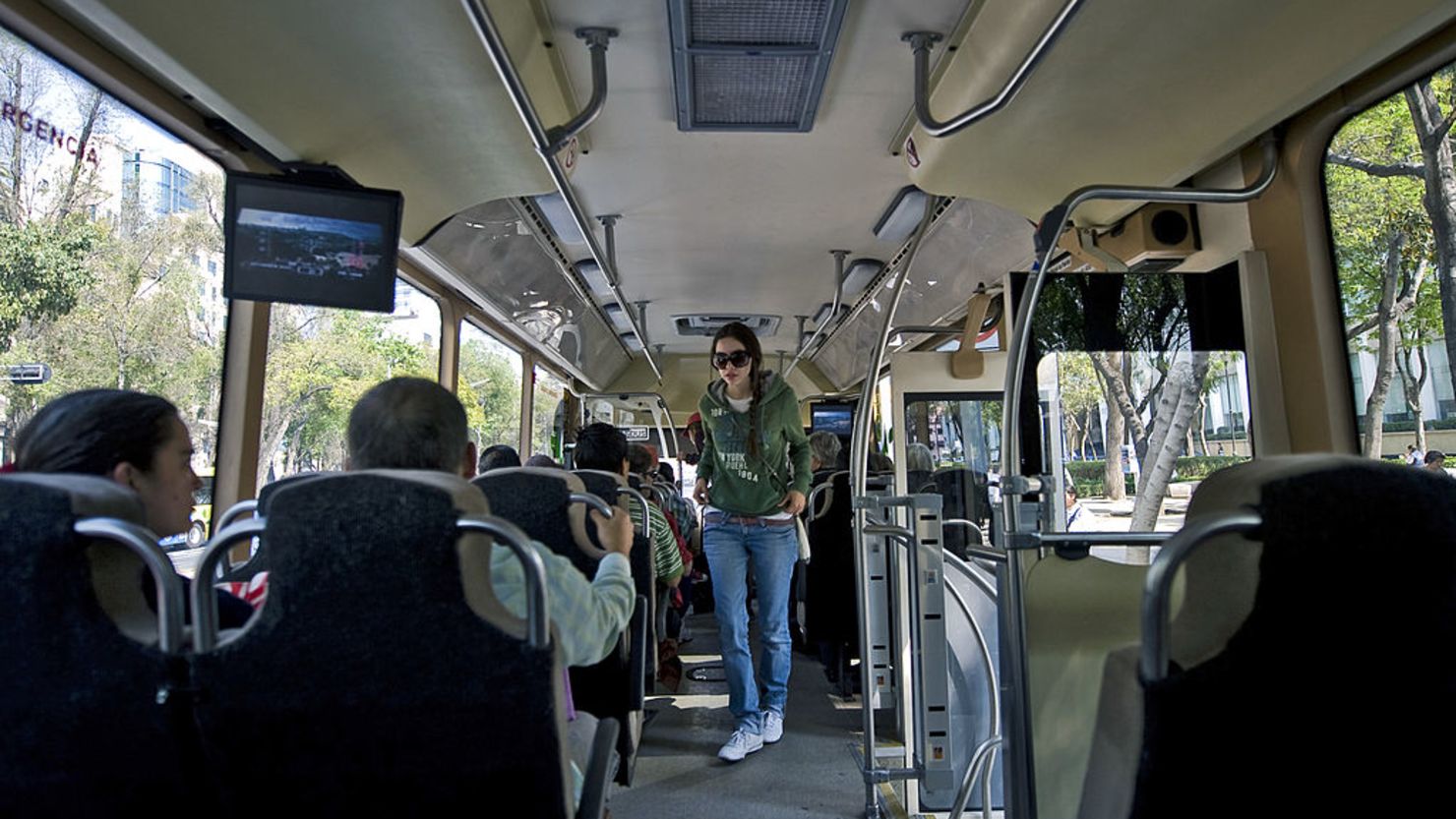 CNNE 249387 - a young woman walks inside a bus at refo