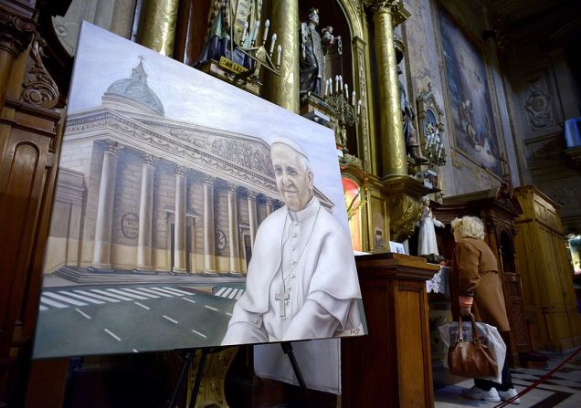 Una mujer ora junto al cuadro de la argentina Mercedes Fariña del papa Francisco el 20 de abril de 2014 en la Basílica de San José de Flores en Buenos Aires.