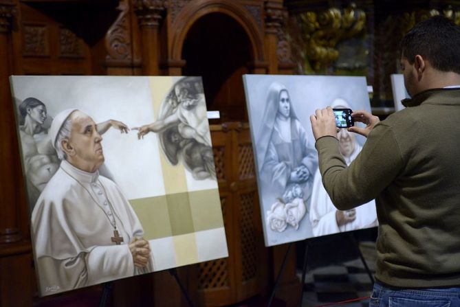 Un hombre toma una foto del cuadro de la argentina Mercedes Fariña sobre el papa Francisco el 20 de abril de 2014 en la Basílica de San José de Flores en Buenos Aires.