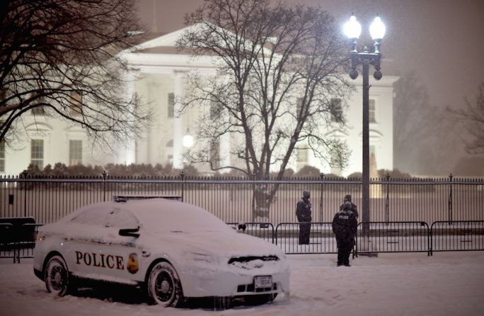 Agentes el Servicio Secreto de EE.UU. resguardan la Casa Blanca durante la fuerte nevada que causó la supertormenta invernal.