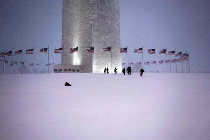 Varias personas caminan en torno al Monumento a Washington, en la capital de EE.UU., que lucía así por la intensa nevada.