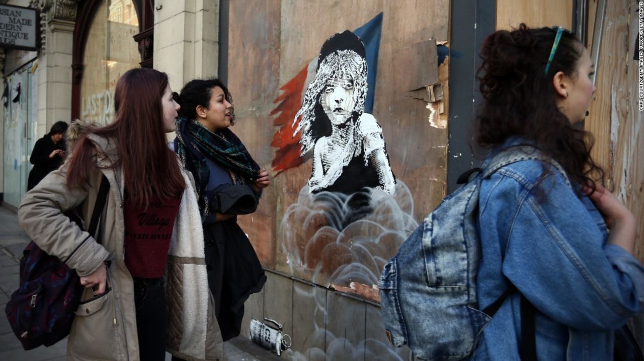 La obra, la cual recrea un cartel del musical francés Les Misérables, muestra a una joven llorando que está envuelta en gas lacrimógeno.