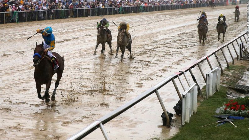 16 DE MAYO DE 2015: En una pista enlodada, Espinoza alza su brazo en señal de victoria en el Preakness Stakes en Baltimore... la segunda de tres carreras que conforman la Triple Corona de Estados Unidos.