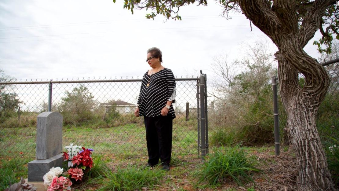 Melba Coody de pie frente a las tumbas de Bazán y Longoria en el Valle del Río Grande, Texas.