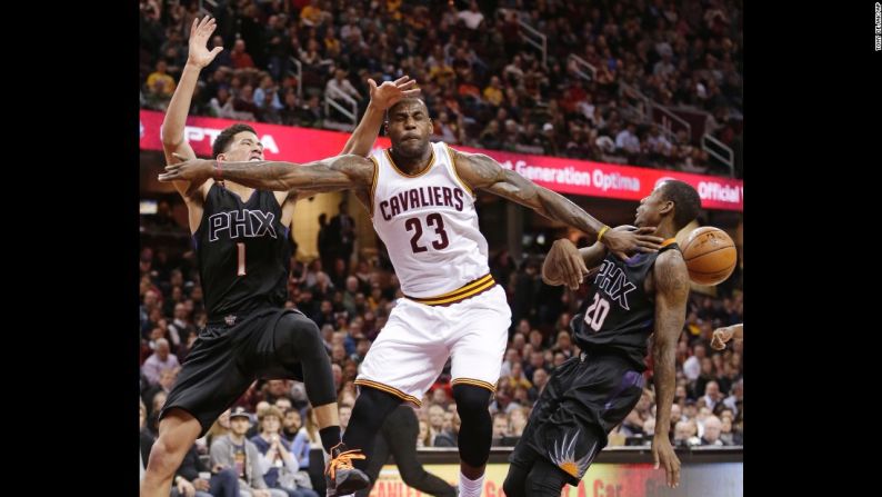 LeBron James, al centro, pierde el control de la pelota a manos de Devin Booker, izquierda, y Archie Goodwin durante un partido de la NBA en Cleveland el miércoles 27 de enero.