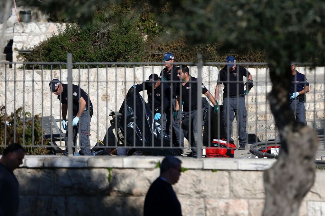 Oficiales de policía israelíes revisan el cuerpo de uno de los agresores que hirieron gravemente a dos policías en la Puerta de Damasco en la entrada de la ciudad vieja de Jerusalén.