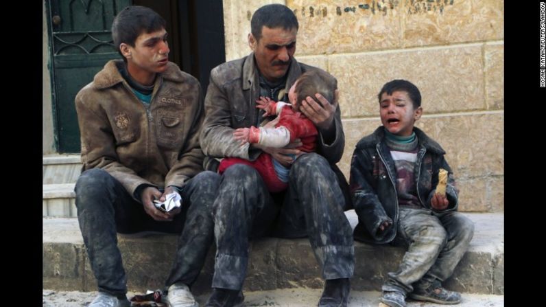 Un hombre sostiene a un bebé que fue rescatado de los escombros de un edificio bombardeado en Aleppo, el 14 de febrero de 2014.