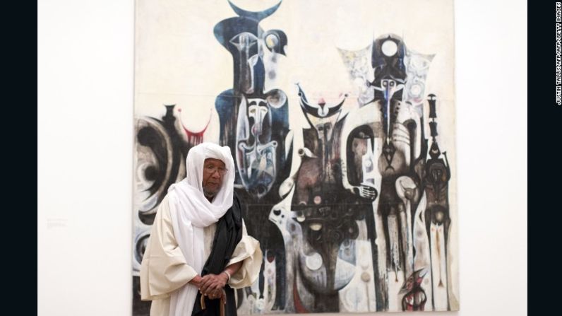 El artista sudanés Ibrahim El-Salahi posa para una fotografía frente a su pintura titulada "Reborn Sounds of Childhood Dreams" en la Tate Modern de Londres.