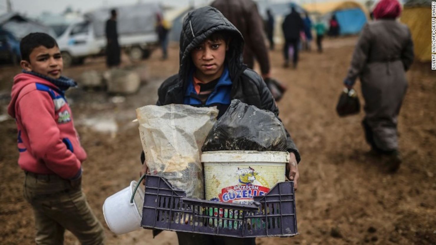 Un niño sirio carga sus pertenencias al llegar como refugiado a la frontera con Turquía el 6 de febrero de 2016.