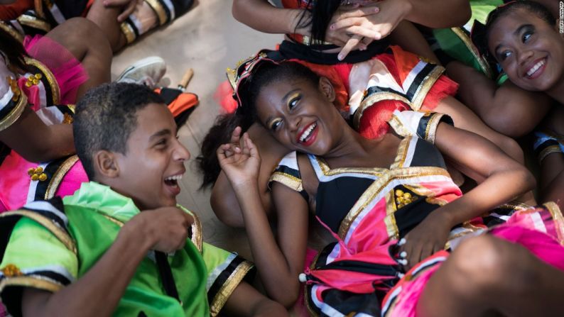 Jóvenes juerguistas bromean unos con otros mientras descansan en la sombra durante un desfile de carnaval en Olinda, Brasil, el 5 de febrero.