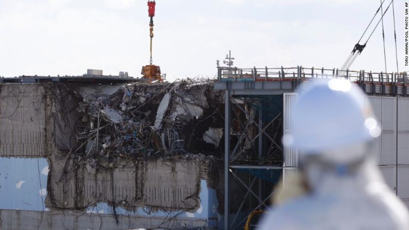 Un miembro del grupo del recorrido que se coloca el traje de protección y una máscara, le da una mirada el 10 de febrero al reactor No. 3 inutilizado.