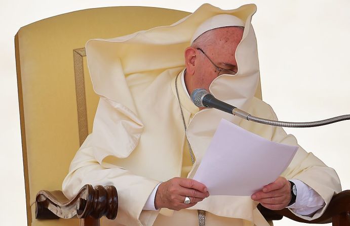 El manto del papa Francisco cubre su rostro durante una audiencia general el 16 de septiembre de 2015 en la Plaza de San Pedro en el Vaticano.