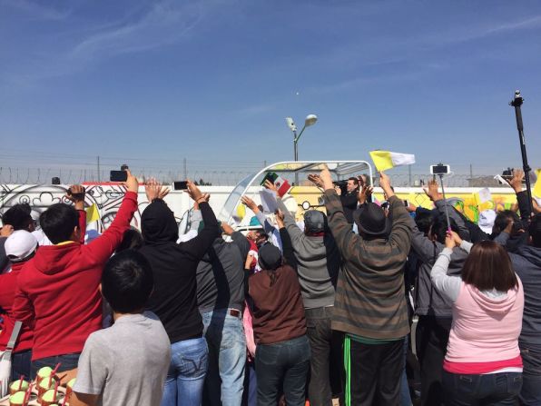 Asistentes toman fotografías del papa Francisco en su papamóvil a su llegada a Ecatepec, en su segundo día visita apostólca en México.