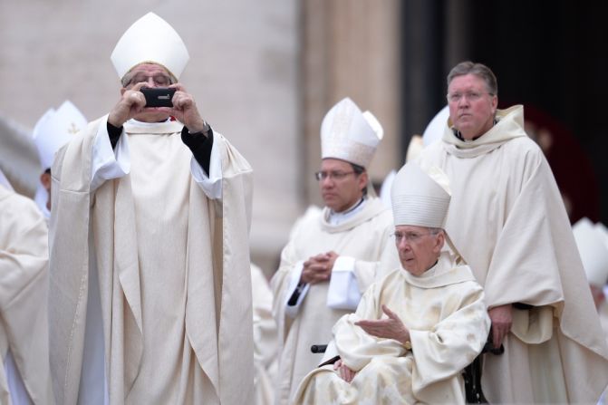 Un cardenal toma una foto a su llegada a la misa de canonización de los Papas Juan XXIII y Juan Pablo II en la plaza San Pedro, en El Vaticano, el 27 de abril de 2014.