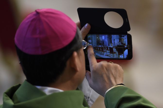 Un obispo toma una foto con su teléfono móvil antes de una misa papal para el cierre de la 14ª Asamblea General Ordinaria del Sínodo de los Obispos en la Basílica de San Pedro, el 25 de octubre de 2015.