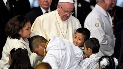 El papa Francisco es recibido por los niños a su llegada al hospital.