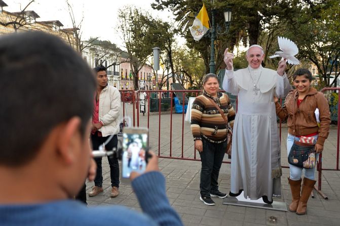 14 de febrero de 2016 - Un niño toma una fotografía de dos mujeres con una imagen de cartón de Francisco en el centro de San Cristóbal de las Casas, Chiapas, México.