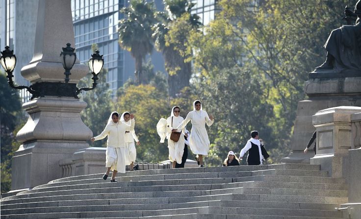 14 de febrero de 2016 - Monjas corren para ver Francisco a su paso por el Ángel de la Independencia, uno de los máximos símbolos de Ciudad de México.