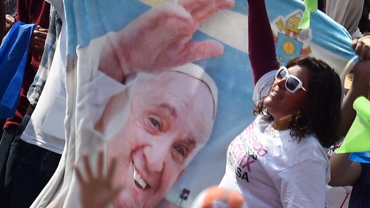 People cheer as Pope Francis arrives for a meeting with young people at the Jose Maria Morelos y Pavon stadium  in Morelia on February 16, 2016. Pope Francis urged Mexican priests and nuns on Tuesday to not despair in the face of violence as he visited a former bastion of a cult-like drug cartel.  AFP PHOTO / GABRIEL BOUYS / AFP / GABRIEL BOUYS