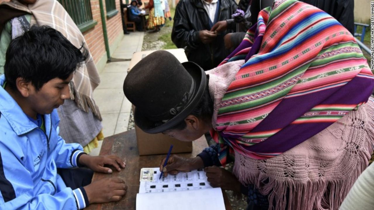 An Aymara indigenous woman places her signature after voting on February 21, 2016 in Huarina, 75 km from La Paz, Bolivia in a referendum on a constitutional reform that would allow Evo Morales to seek a fourth term as president, potentially extending his stay in office until 2025. Morales, Bolivia's first indigenous president, was first elected to office in 2006 and re-elected twice. His current term ends in 2020. AFP PHOTO/Aizar Raldes / AFP / AIZAR RALDES