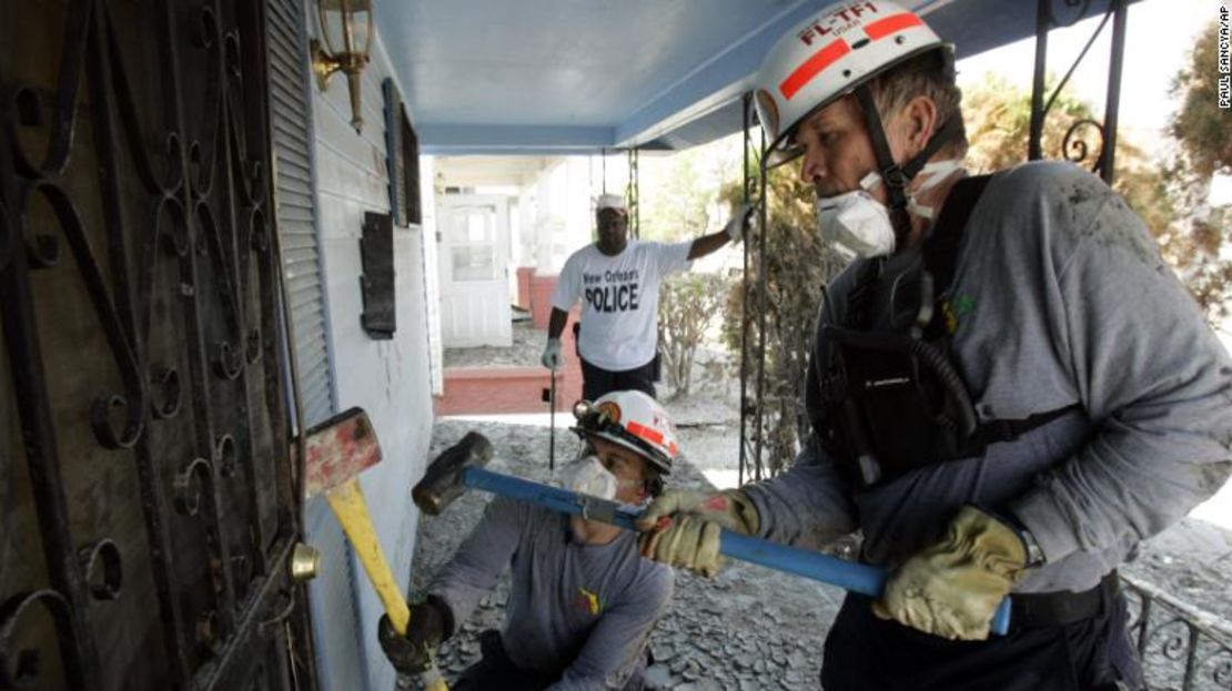 Miembros del equipo Florida Task Force-1 tumban una puerta para revisar una casa en Nueva Orleans después del huracán Katrina en 2005.