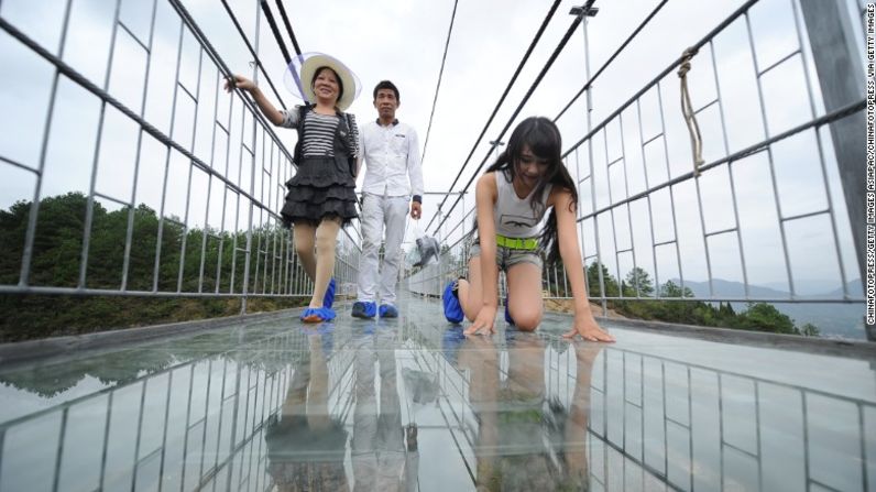Unas turistas visitan el puente con piso de cristal en el Parque Nacional Natural Shiniuzhai en China.