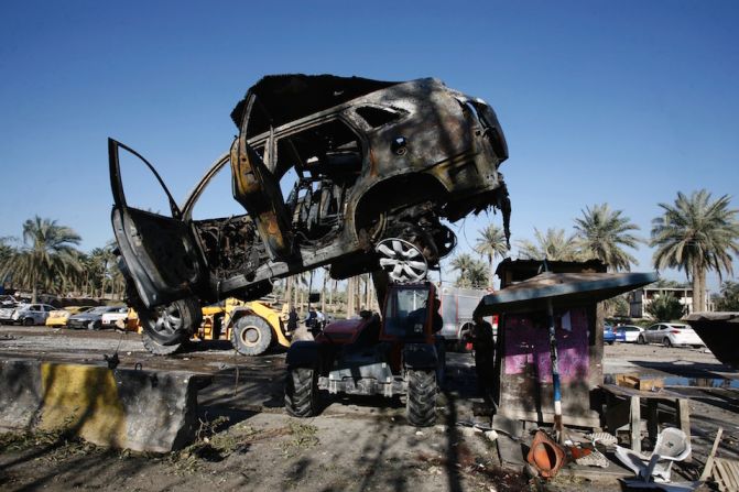 Cuerpos de seguridad limpian el lugar en el que ISIS hizo explotar un camión bomba, en Hilla, Iraq.