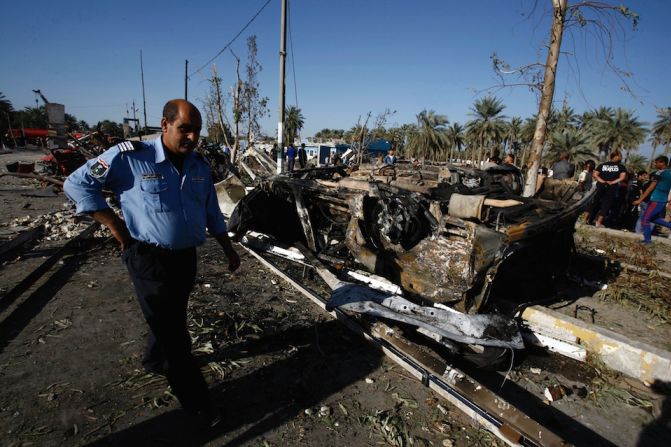 Cuerpos de seguridad limpian el lugar en el que ISIS hizo explotar un camión bomba, en Hilla, Iraq.