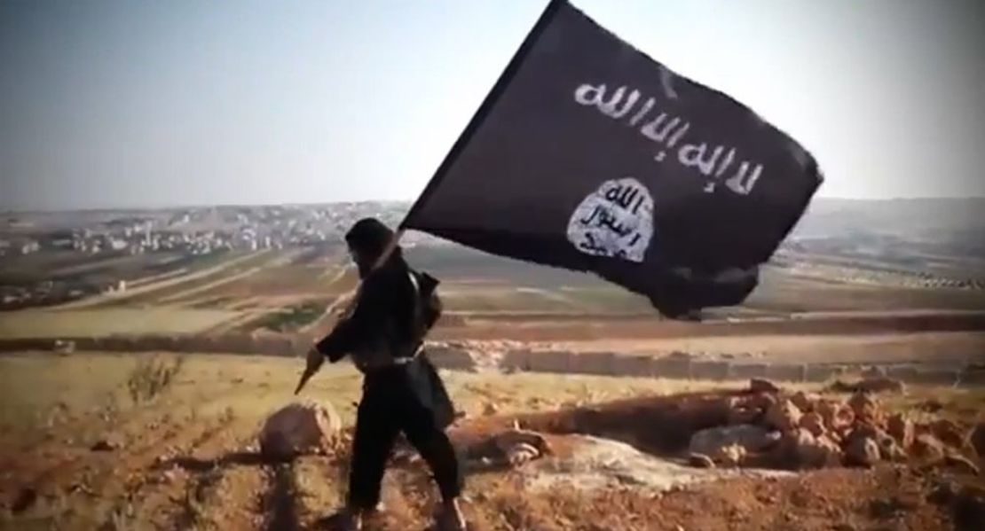 El miembro de una filial del ISIS en Iraq muestra la bandera del grupo (AFP/Getty Images).